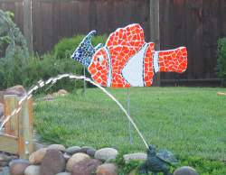 Tile Mosaic fish sculptures in yard by pond.