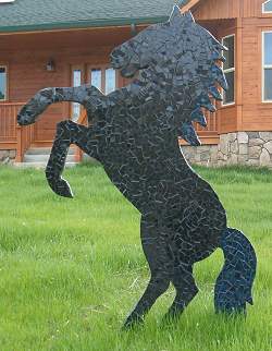Spectacular black stallion horse sculpture is a focal point of the yard or garden.